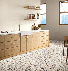 Carrelage effet terrazzo offrant des tons de terre et pierre.
